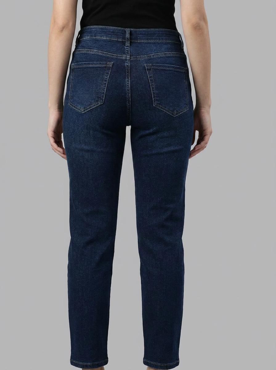 Person wearing dark blue jeans on a gray background