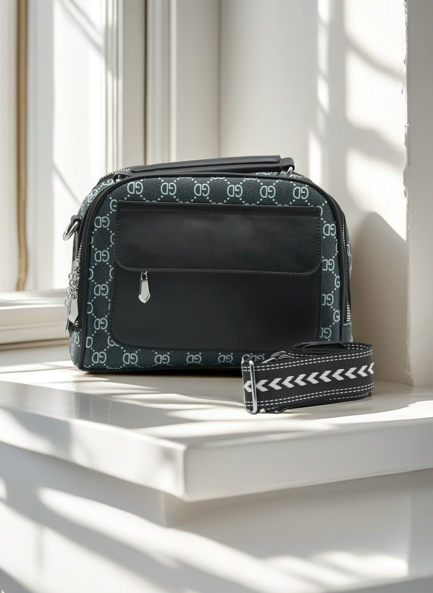 Black bag with a pattern on a white surface near a window