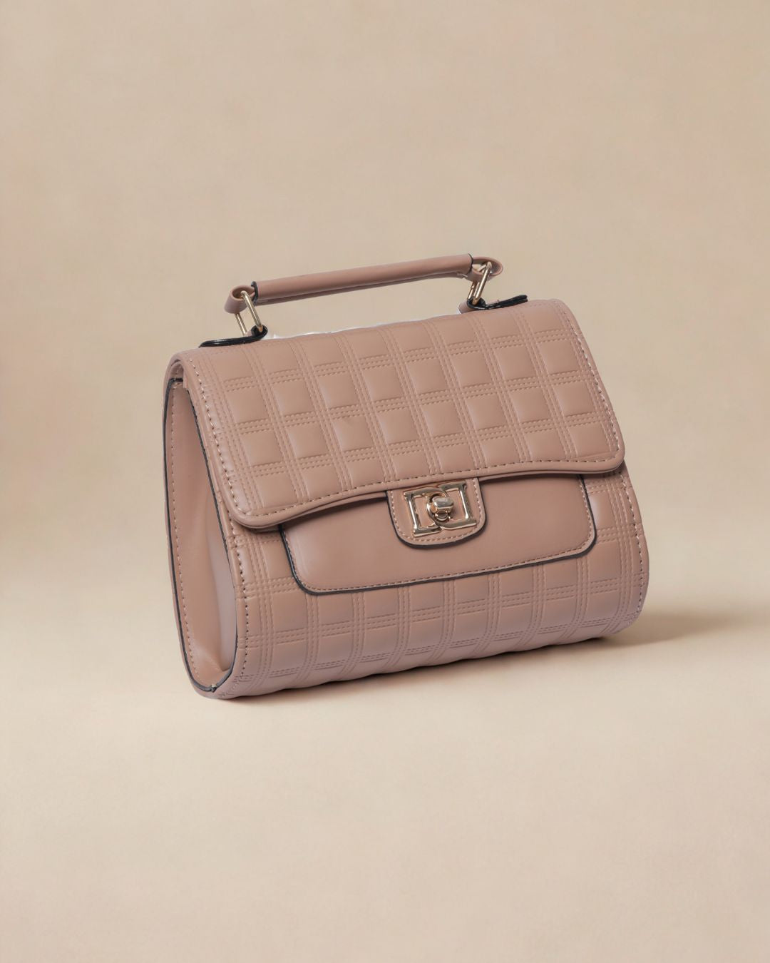 Pink quilted handbag on a beige background