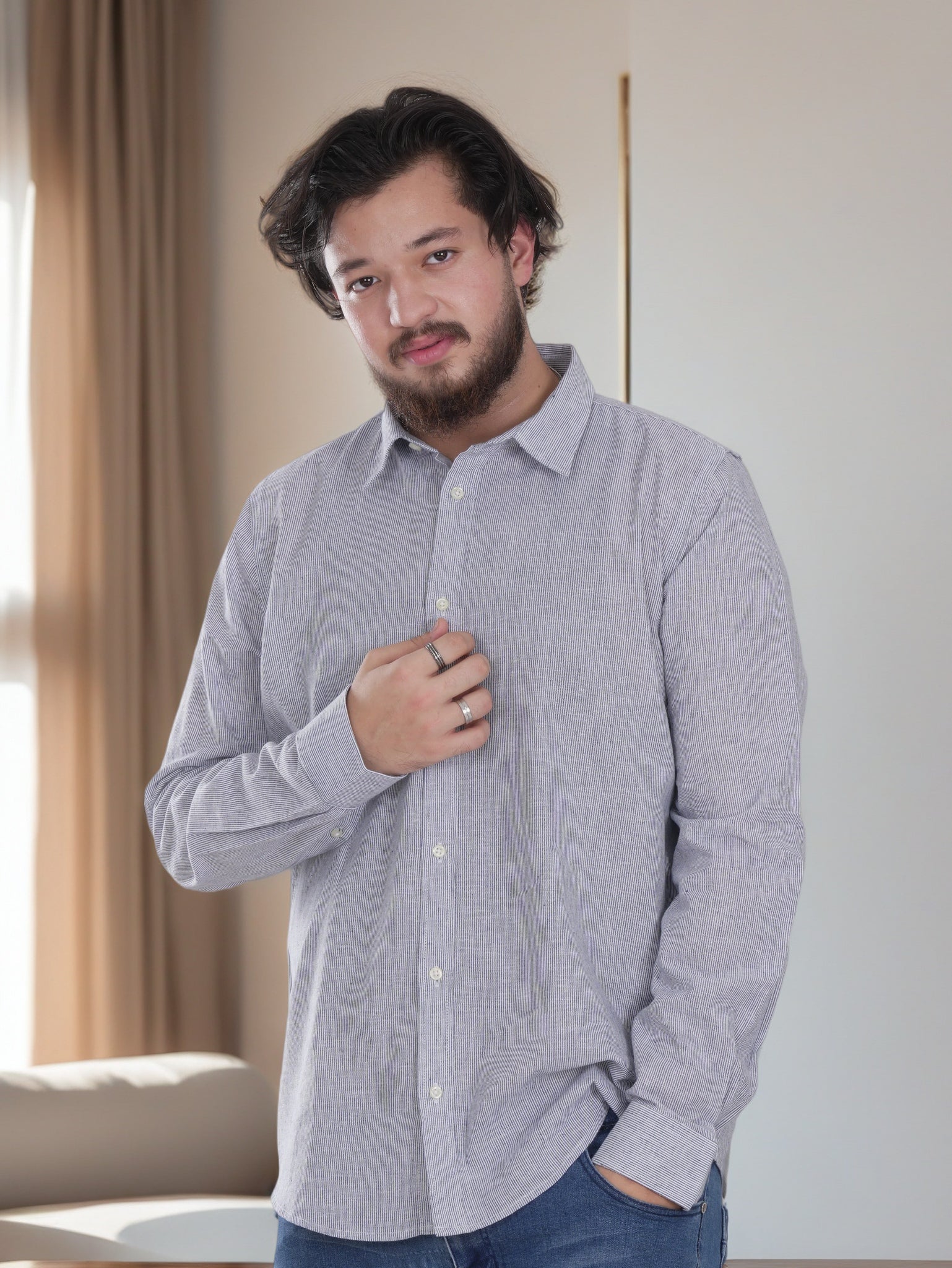 Man wearing a gray button-up shirt in a room with neutral decor