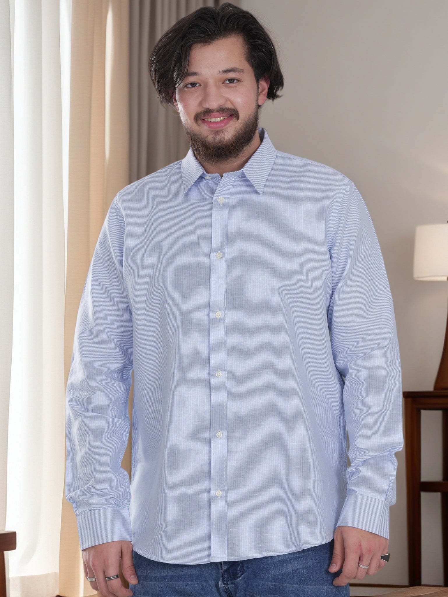 Man wearing a light blue button-up shirt in an indoor setting