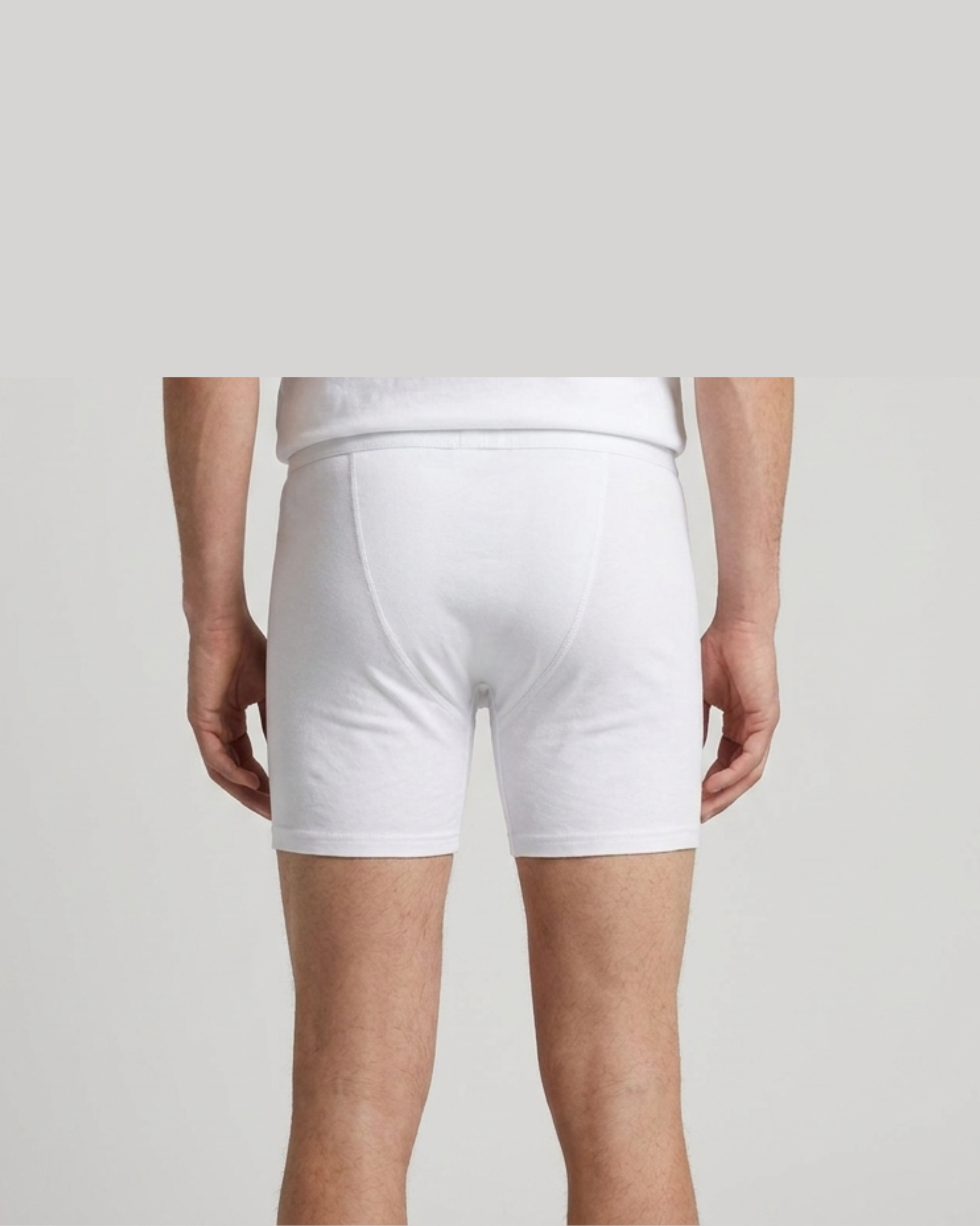 White boxer briefs worn by a person on a light gray background
