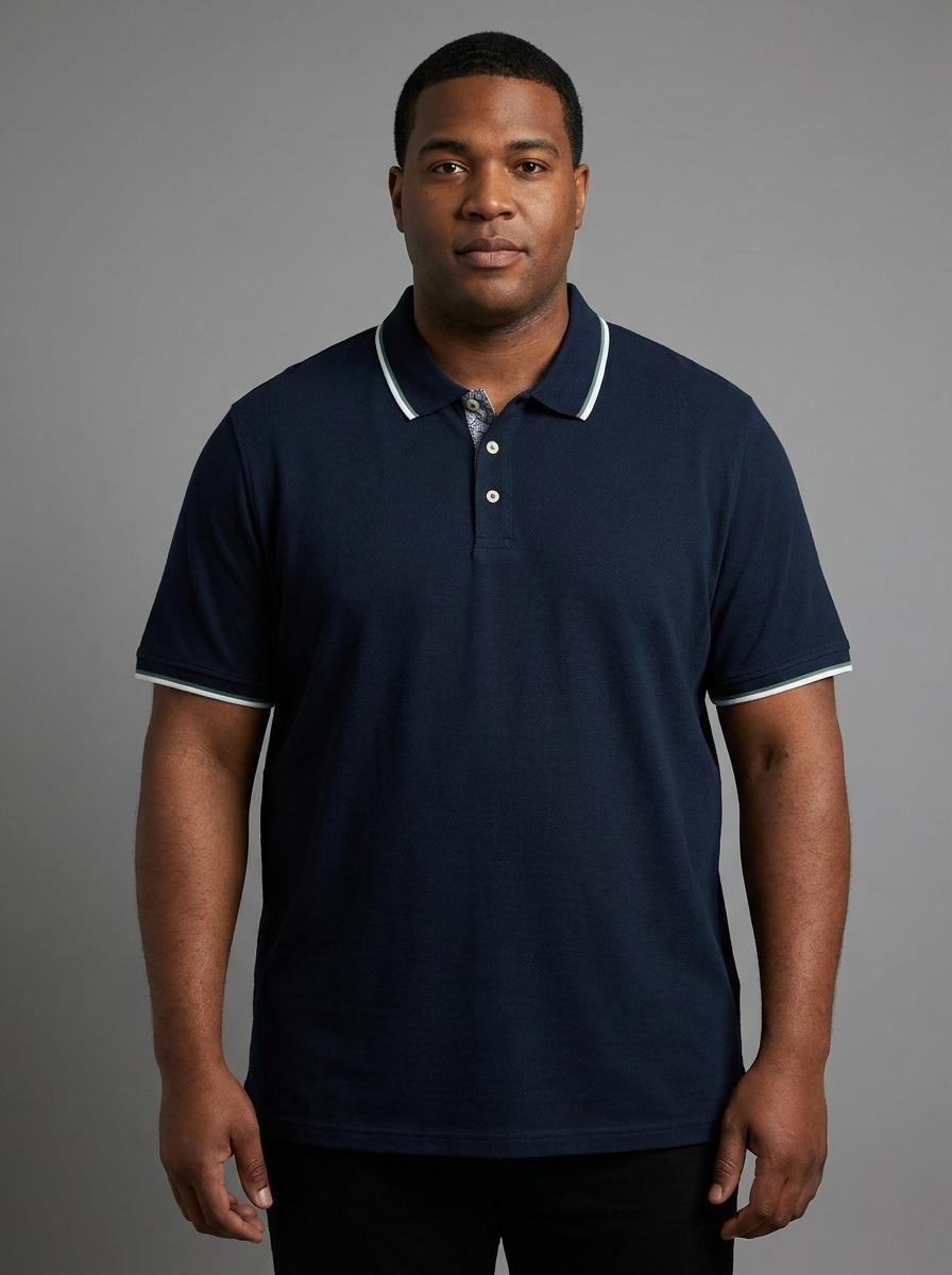 Man wearing a navy blue polo shirt with white trim against a gray background
