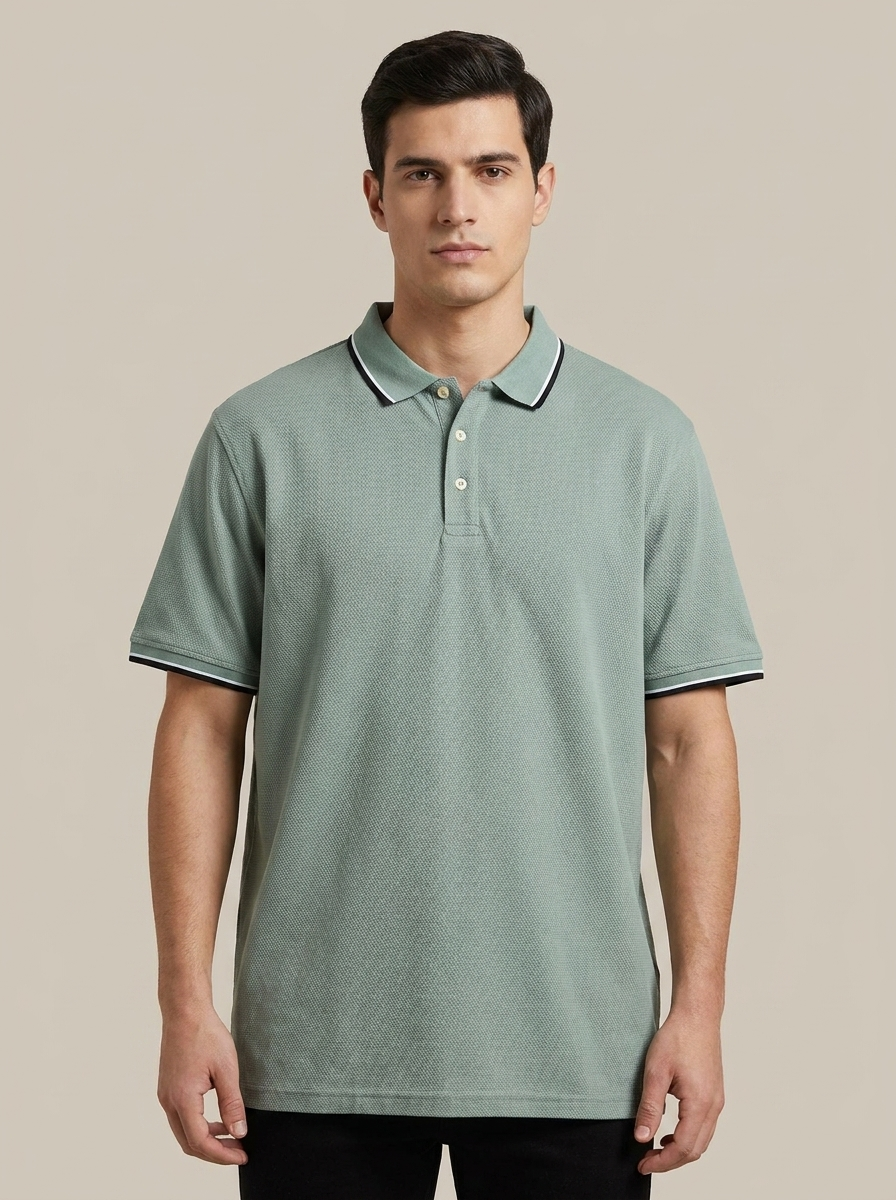 Man wearing a green polo shirt against a beige background