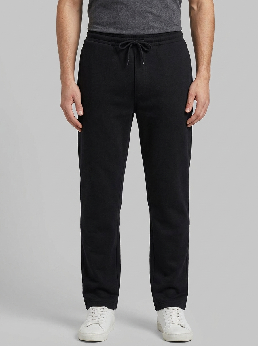 Person wearing black sweatpants on a gray background
