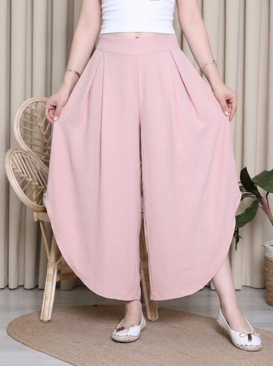 Person wearing pink wide-leg pants in a home setting