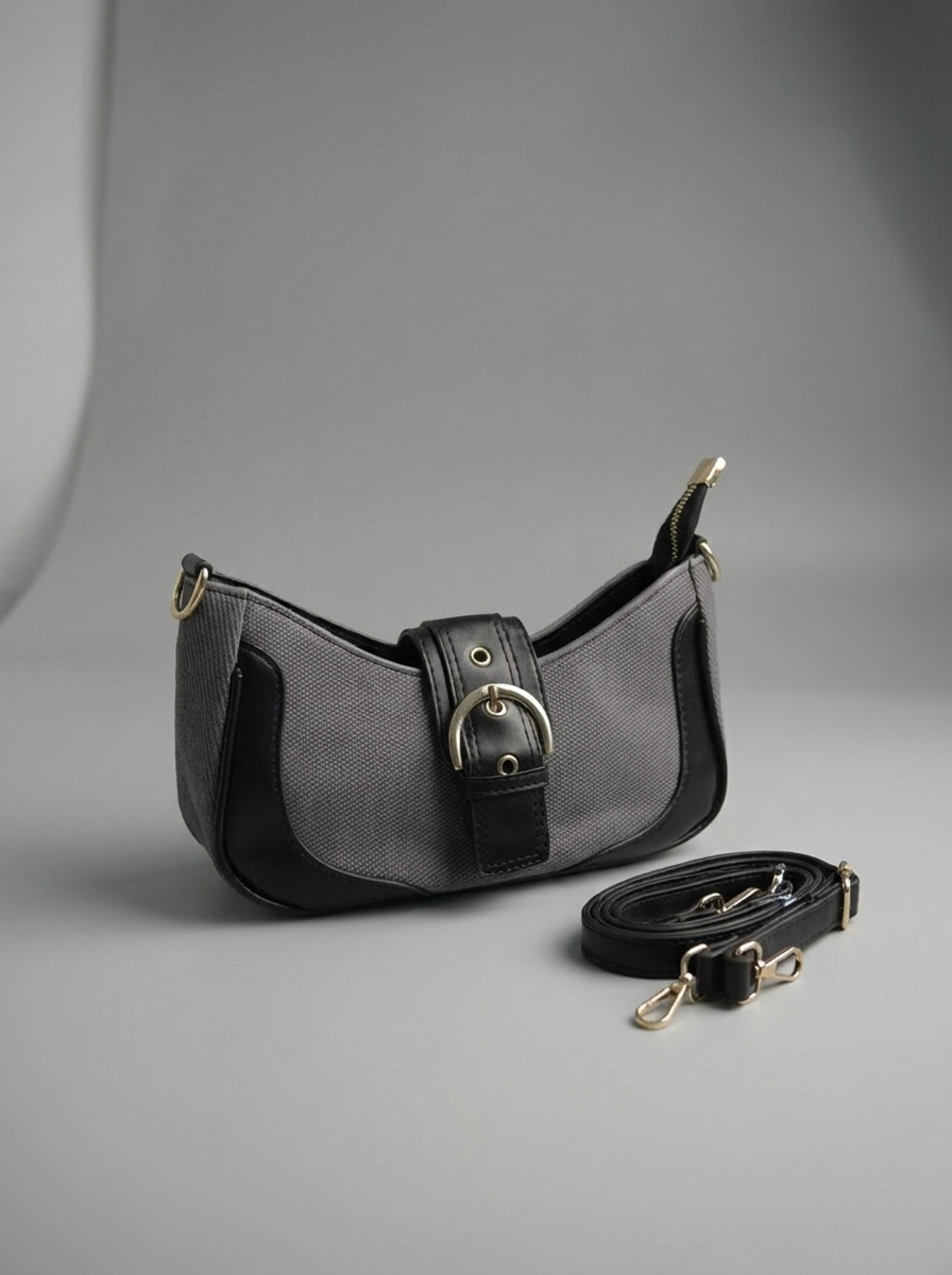 Black and gray handbag with a strap on a gray background