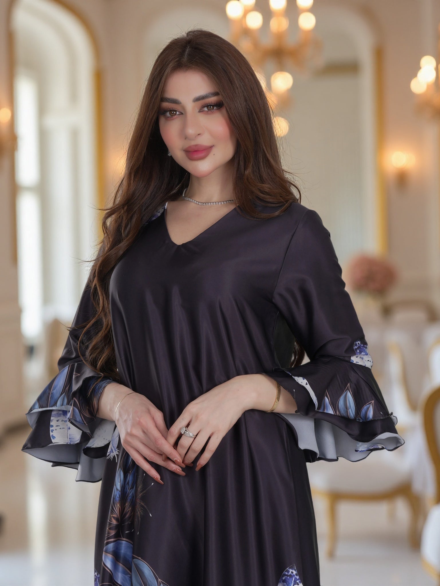 Woman wearing a dark blue dress with floral cuffs in an elegant interior setting
