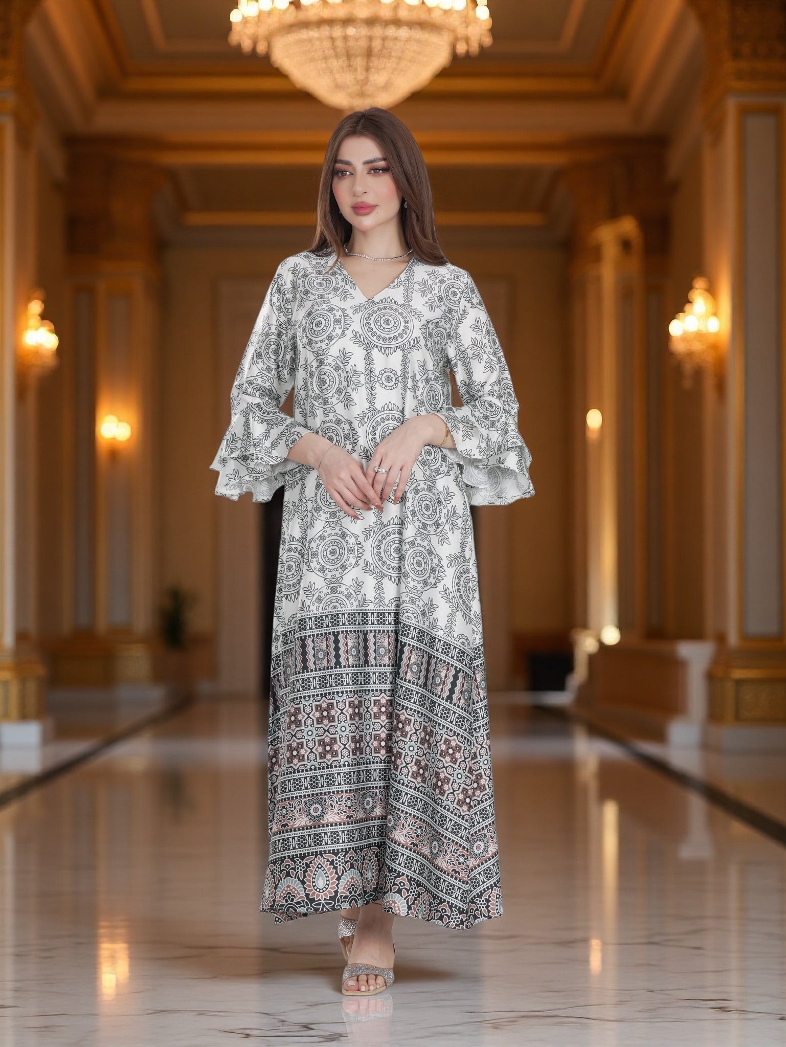 Woman in a patterned dress standing in an elegant hallway with chandeliers.
