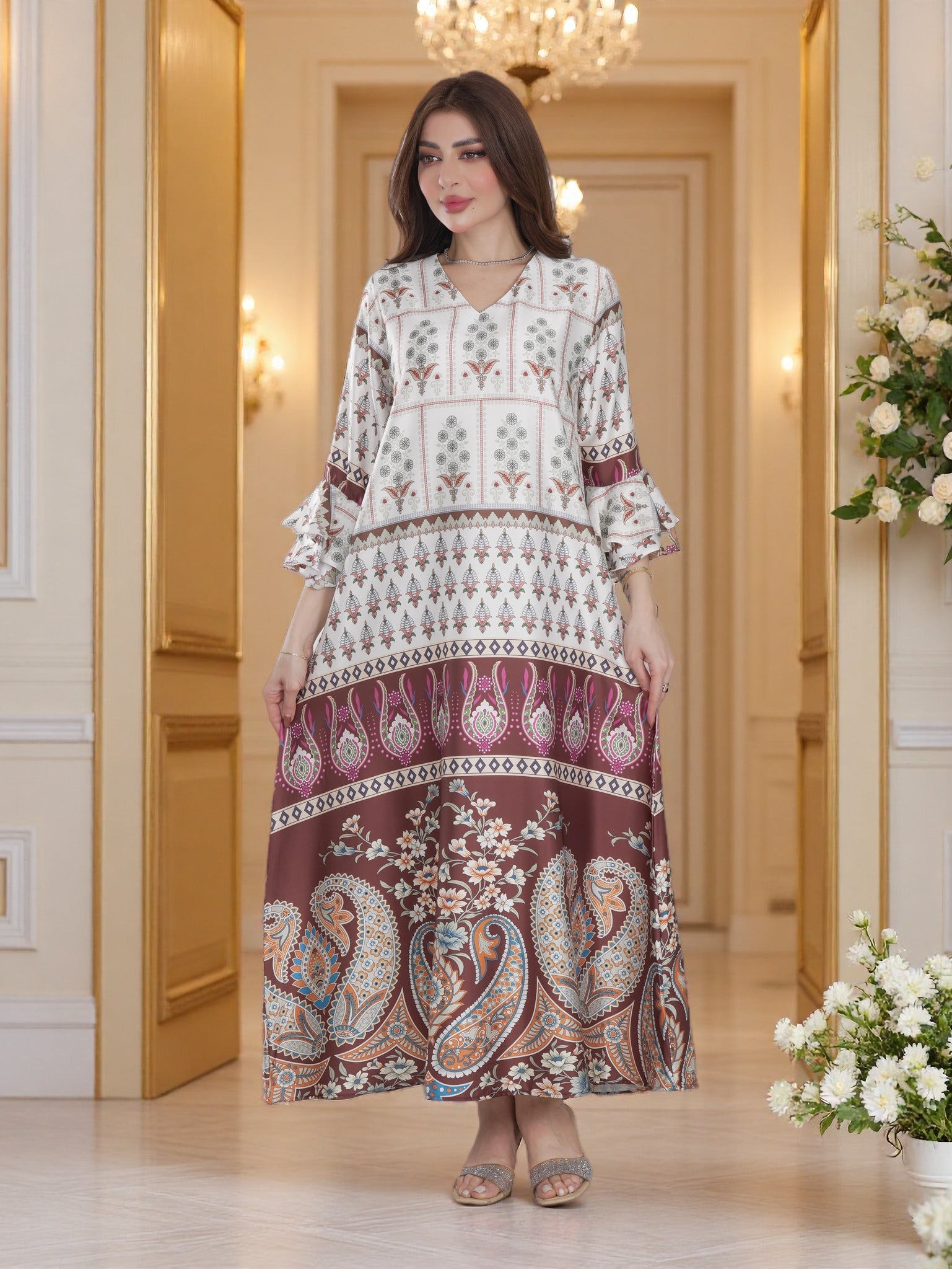 Woman wearing a patterned dress in an elegant interior setting with flowers and chandelier.