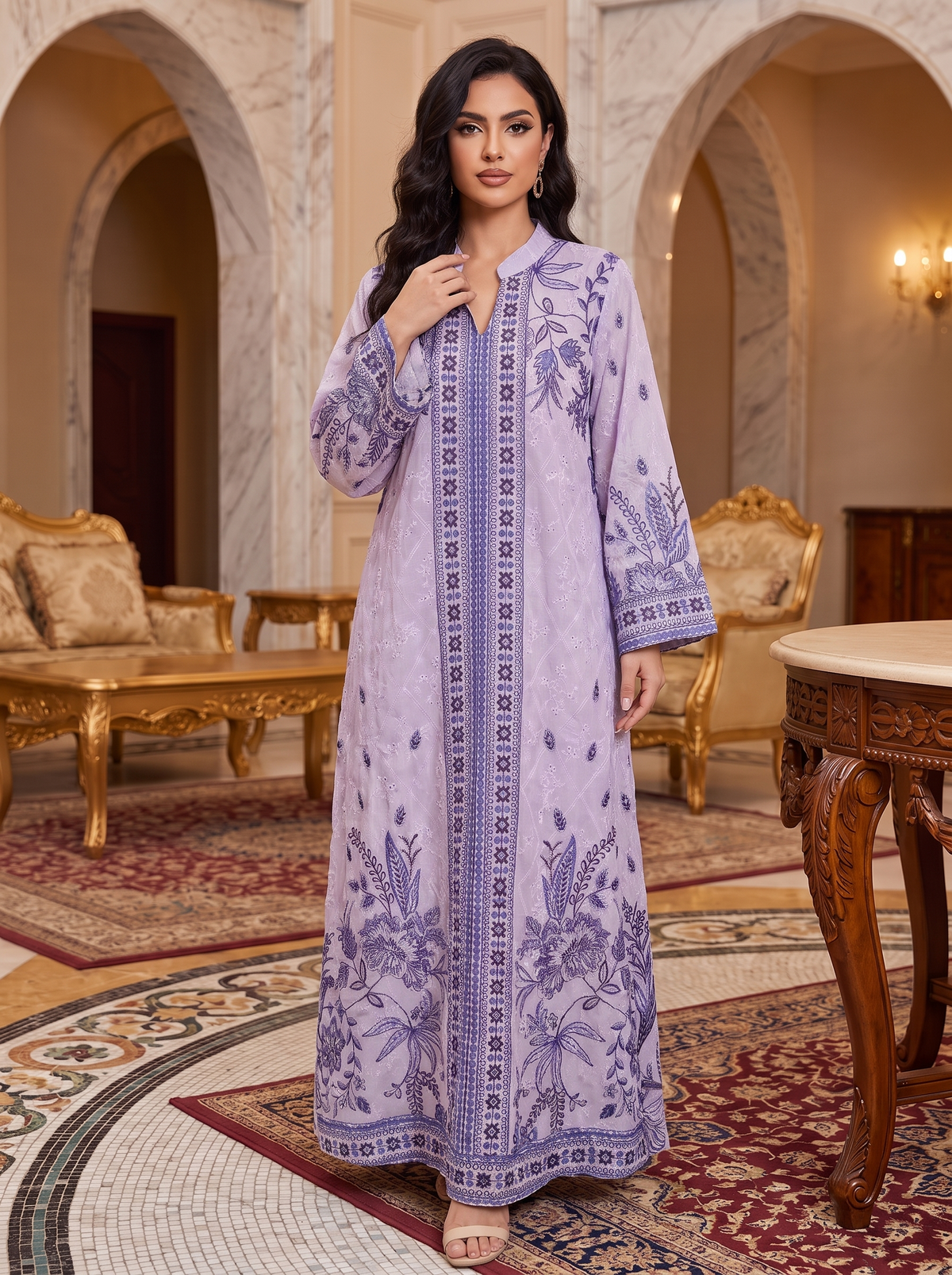 A woman stands in an ornate indoor room wearing a long lavender embroidered kurta with matching embroidered border and botanical motifs. The setting includes marble arches, gold furniture, and patterned rugs.